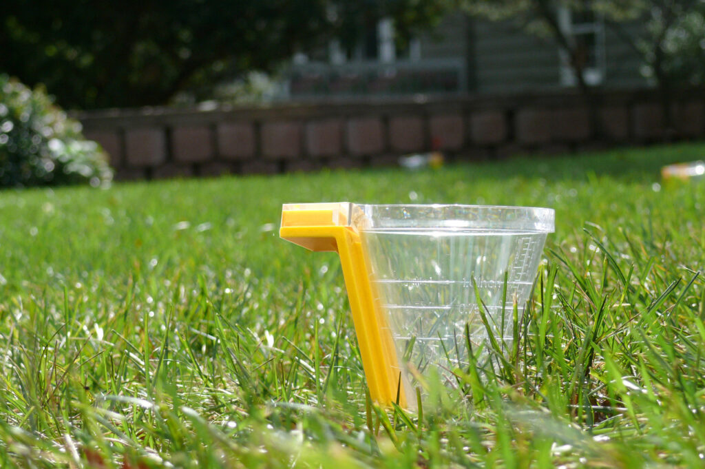 A rain gauge installed in a residential lawn measuring precipitation to support efficient irrigation scheduling in Dayton Ohio